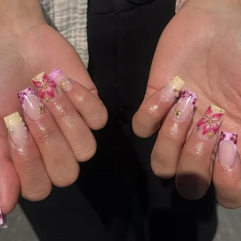 Kurze Gelnägel mit pinkem Blumendesign und Strasssteinen