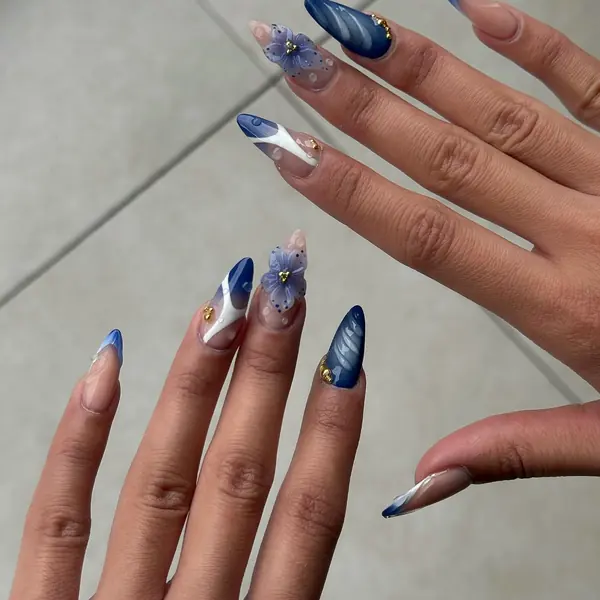 Mandelnägel in Dunkelblau und Weiss mit violetter 3D-Blüte und Wassertropfen-Effekt