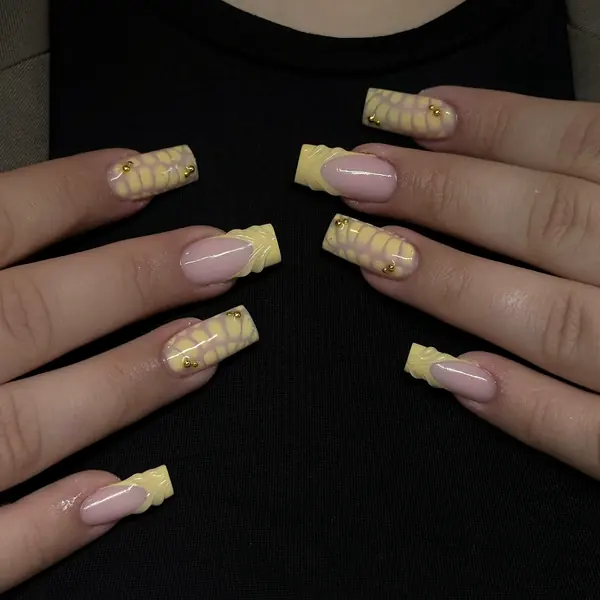 Lange eckige Nägel in Pastellgelb und Rosa mit 3D-Krokodilstruktur und Goldperlen