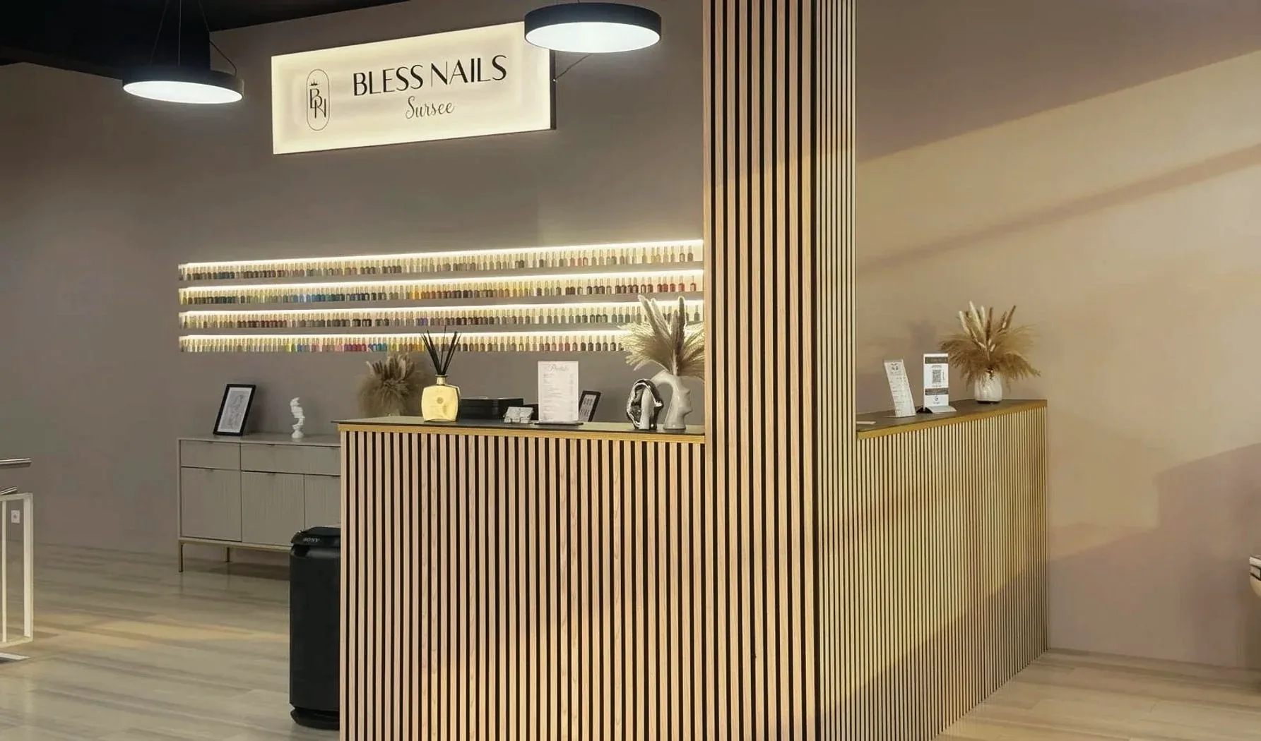Empfang mit Bless-Nails-Logo und Wand voller Nagellackfarben